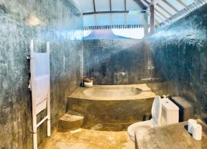 a dirty bathroom with a toilet and a bath tub at Villa Lautan Biru Bingin Beach in Uluwatu +82 photos