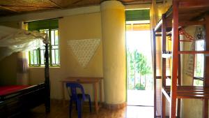 a bedroom with a bed and a table and a window at SINA Village in Mpigi