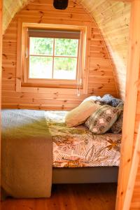 a bed in a log cabin with a window at Champagne Philippe Martin in CumiÃ¨res