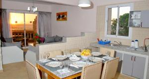 una cucina con tavolo e sedie e una cucina con tavolo di Kaouki beach Apart'hotel a Sidi Kaouki