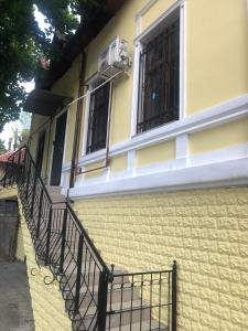 een geel gebouw met een balkon en een raam bij Friends Hostel in Chişinău