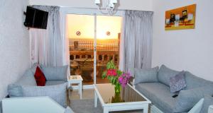 Kaouki beach Apart'hotel في سيدي كاوكي: غرفة معيشة مع أريكة وطاولة