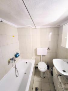 a bathroom with a tub and a toilet and a sink at 3BR Spacious City Center in Thessaloniki