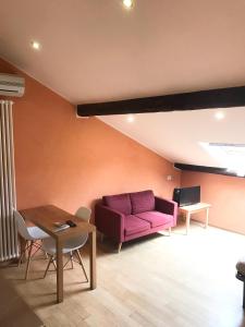 een woonkamer met een paarse bank en een tafel bij Casa Cairoli in Milaan