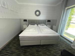 a bedroom with a bed and two tables and a window at Apartament Luxury 5 Mórz in Sianozety