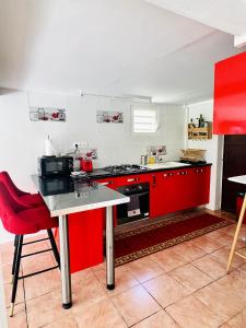een keuken met rode kasten en een rood aanrecht bij Appartement de 2 chambres avec jardin et wifi a Petit Bourg in Petit-Bourg
