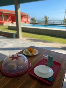 a wooden table with plates of food on it at Takito Kite House, Praia da Baleia, Itapipoca CE in Franco