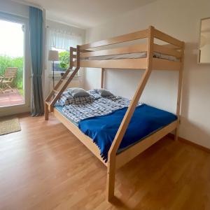 Dormitorio con litera y edredón azul en Ferienapartment Casa Heideblick mit Sonnenterrasse & Garten, en Radeberg