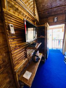 高哈蒂的住宿－Tridhara HomeStay，一间设有木墙的客房,配有电视