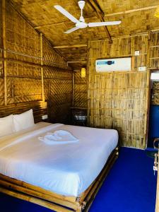 高哈蒂的住宿－Tridhara HomeStay，稻草小屋内一间卧室,配有一张床