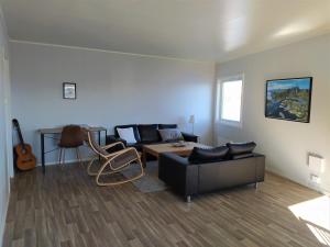 ein Wohnzimmer mit einem Sofa und einem Tisch in der Unterkunft Fish factory -The real Lofoten experience in Ballstad