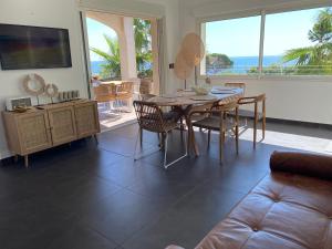 - un salon avec une table, des chaises et un canapé dans l'établissement Villa Jungle Beach, à Sainte-Maxime