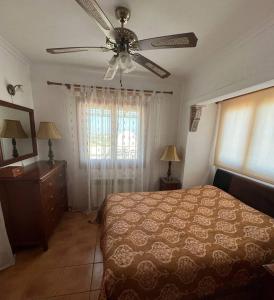 a bedroom with a bed and a ceiling fan at Villa vistas panorámicas in Denia
