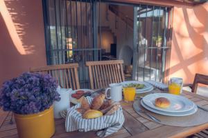 a wooden table with plates of food and orange juice at Onyria Quinta da Marinha Villas in Cascais