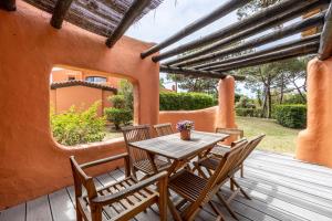 einen Holztisch und Stühle auf einer Holzterrasse in der Unterkunft Onyria Quinta da Marinha Villas in Cascais