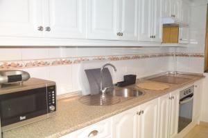 una cocina con fregadero y microondas en Holiday House Gara, en San Sebastián de la Gomera 9 fotos más