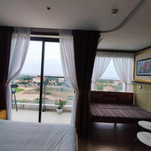 a bedroom with a bed and a large window at Beach apartment apec Phú Yên in Tuy Hoa