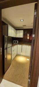 a small kitchen with a refrigerator and white cabinets at EMAN HOUSE in Salalah