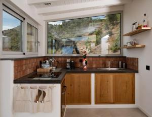 uma cozinha com um lavatório e uma grande janela em Villa Magliolo em Cefalù
