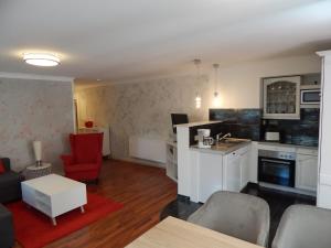 ヴェルニゲローデにあるFerienwohnung Haus Bettinaのキッチン、リビングルーム(赤い椅子付)