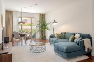 フンシャルにあるQuinta da Falésia II by An Island Apartの青いソファとテーブルのあるリビングルーム