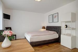 ein Schlafzimmer mit einem Bett und einer Vase mit Blumen in der Unterkunft Apartment Landzeit in Neukirch