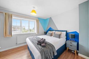 a bedroom with a bed with blue walls and a window at Waterside House - Free Parking in Hoo