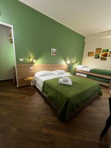 een slaapkamer met een bed en een groene muur bij All’Anoneto B&B in Catona