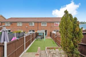 a backyard with a fence and a house at Waterside House - Free Parking in Hoo