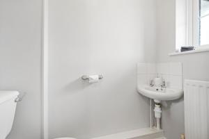 La salle de bains blanche est pourvue d'un lavabo et d'une douche. dans l'établissement Waterside House - Free Parking, à Hoo