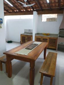 a wooden table and a bench in a kitchen at Maré Mansa Barê in São Sebastião
