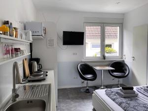 a kitchen with a sink and two chairs in a room at Zimmervermietung Berlin-Spandau in Berlin