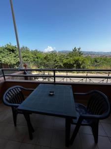 een blauwe tafel en stoelen op een balkon met uitzicht bij All’Anoneto B&B in Catona