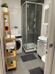 y baño con ducha y lavadora. en Paris 16 Victor Hugo superbe studio, en París