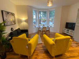 De Parys Flat 1 in Bedford في بيدفورد: غرفة معيشة مع كراسي صفراء وطاولة