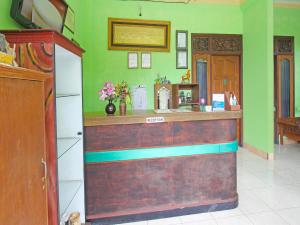 um bar num restaurante com paredes verdes em OYO 91564 Ayodya Guest House em Mataram