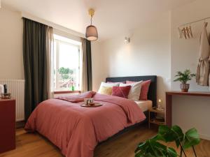 a bedroom with a bed with a red blanket and a window at Rûte - Bed no Breakfast in Bruges