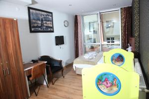 Habitación de hotel con cama, escritorio y habitación con cama en GARDEN HILL HOTEL, en Estambul