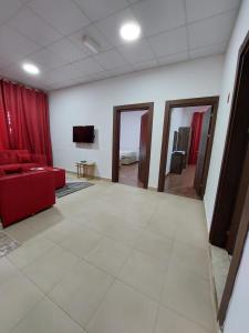 uma sala de estar com um sofá vermelho e uma televisão em EMAN HOUSE em Salalah