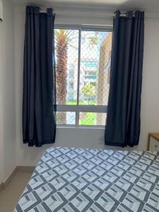 1 dormitorio con cama y ventana grande en Beach Place Aquiraz Riviera, en Aquiraz