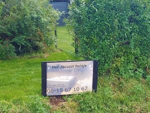 ein Schild, auf dem hohe Gefahrenmusik im Gras steht in der Unterkunft Jacuzzi huisje De Berenshoeve in Emmen