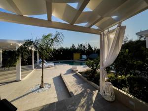 a patio with a palm tree and a pool at Relais Belvedere in Giovinazzo