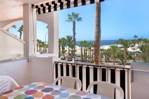a balcony with a table and chairs and a view of the beach at Casa Princesa in Playa del Cura