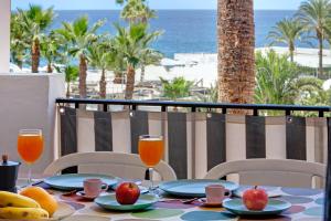 una mesa con fruta y bebidas en un balcón con vistas a la playa en Casa Princesa, en Playa del Cura