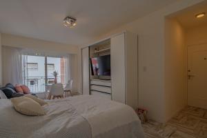 a bedroom with a large bed with a television in it at Berlina Hermoso ambiente c/balcón a la calle in Mar del Plata