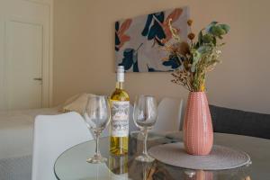 una botella de vino y dos copas de vino en una mesa en Berlina Hermoso ambiente c/balcón a la calle en Mar del Plata