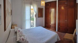 1 dormitorio con cama blanca y ventana en Beach-Golf House, en Islantilla