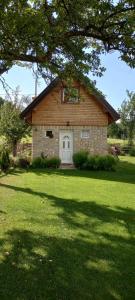 a stone house with a white door in a yard at Vikendica Raković in Zlatibor