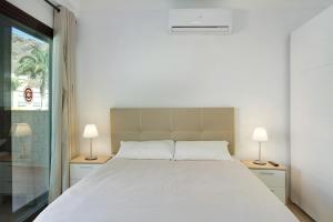 ein Schlafzimmer mit einem weißen Bett und zwei Lampen in der Unterkunft Apartamento Pedro in Puerto de Mogán