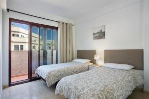 ein Hotelzimmer mit zwei Betten und Balkon in der Unterkunft Apartamento Pedro in Puerto de Mogán